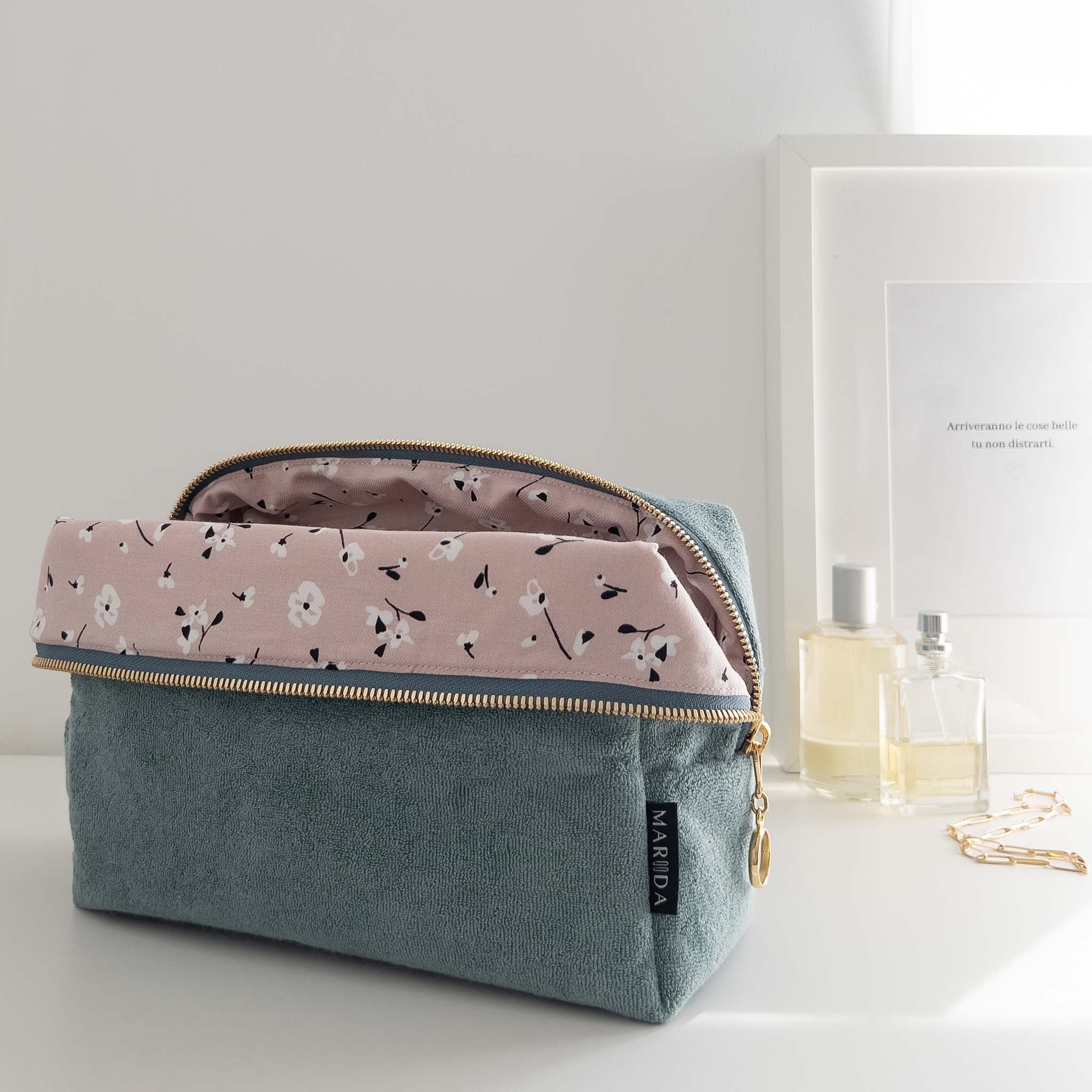Trousse in spugna certificata GOTS color petrolio con fodera rosa e fiorellini bianchi